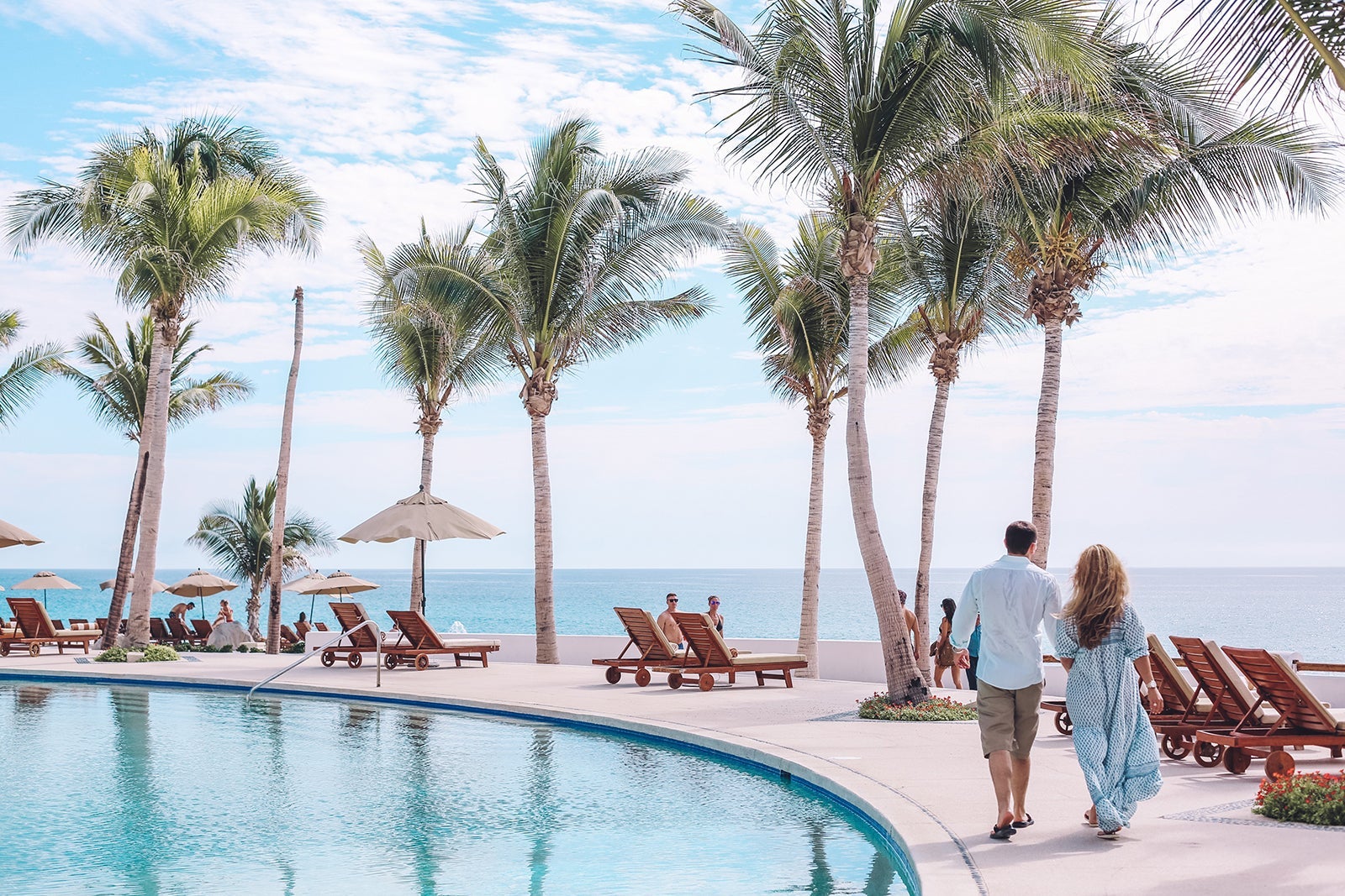 couple walking along pool at Marquis Los Cabos