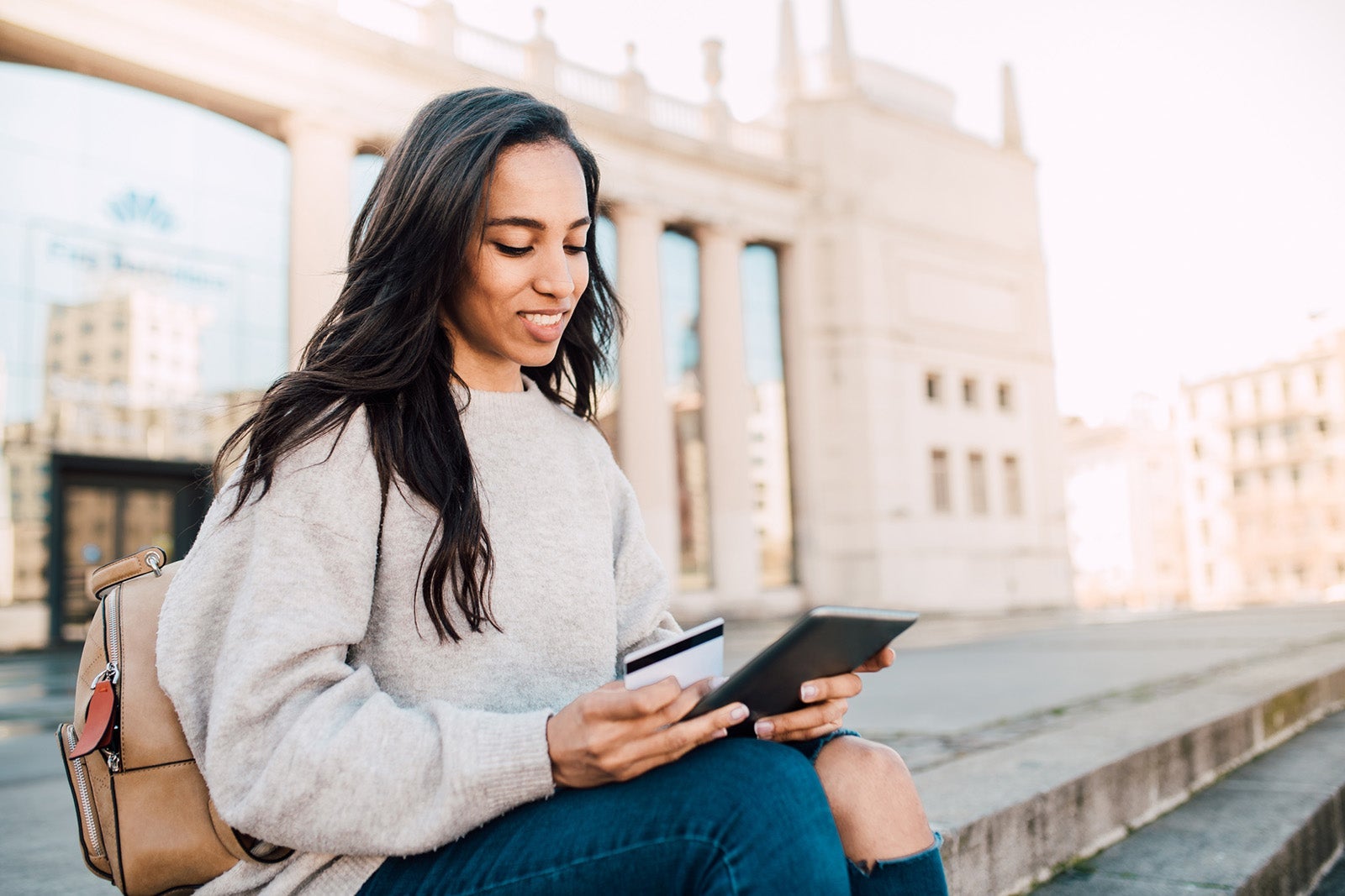 Woman holding a credit card and a tablet