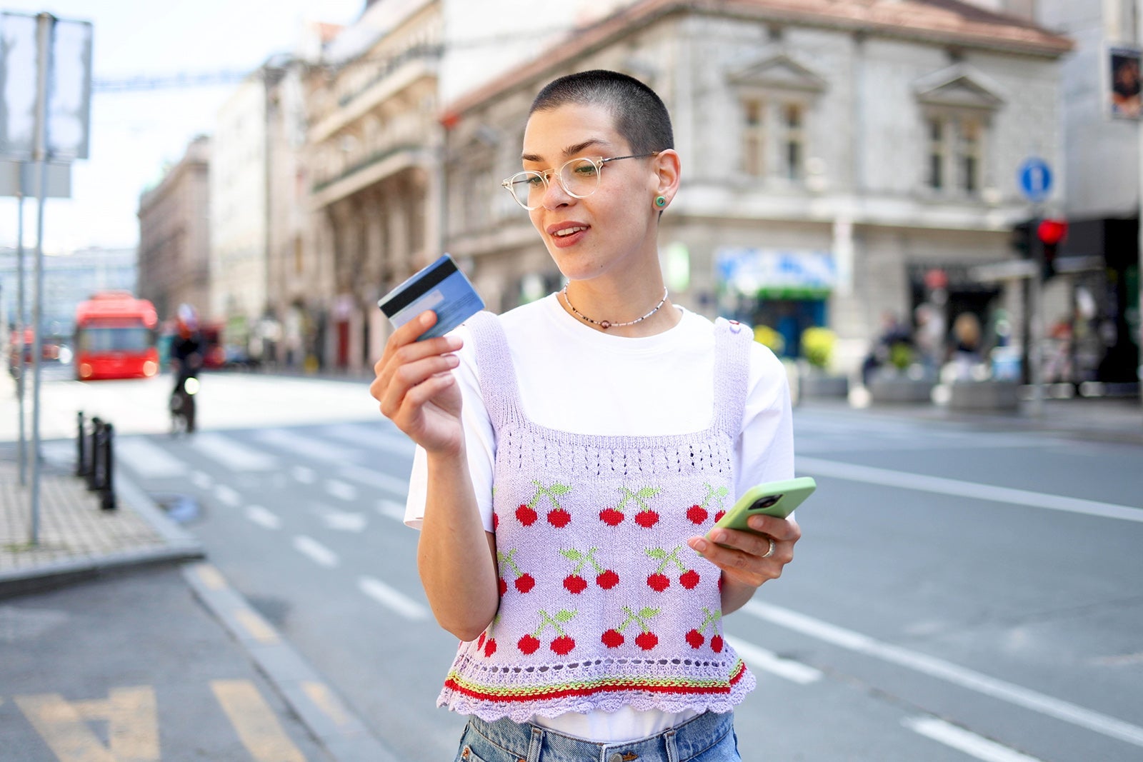 Young short-haired woman using smartphone on the street