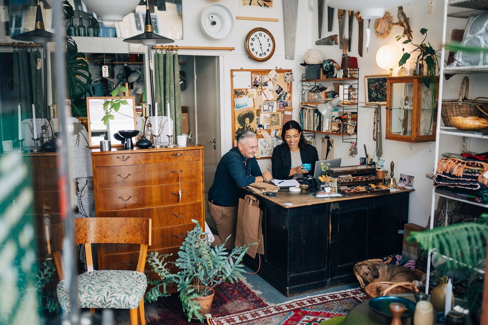 Smiling male and female owners discussing at antique shop