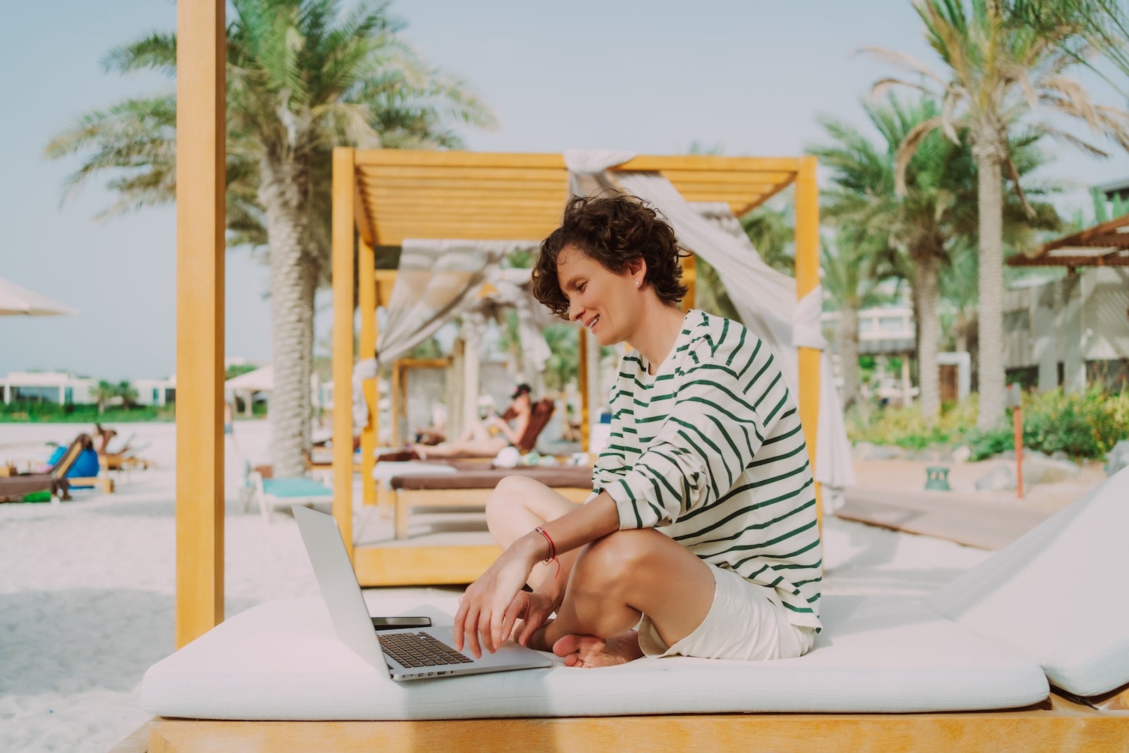Trader occupation and business calls on the beach. Smiling businesswoman is digital nomad, works remotely from beach location